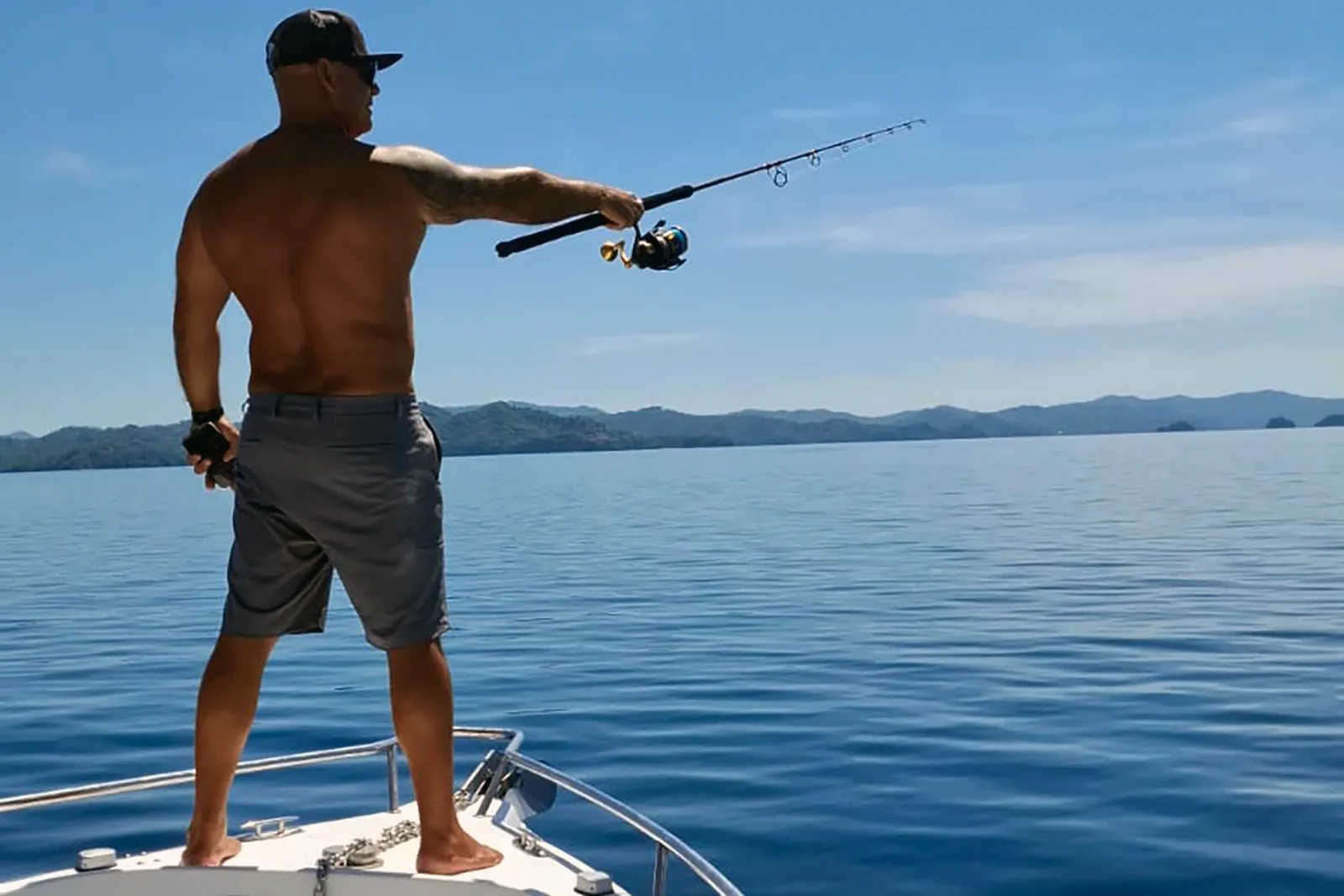 Captain Marcy casting a fishing rod from the boat