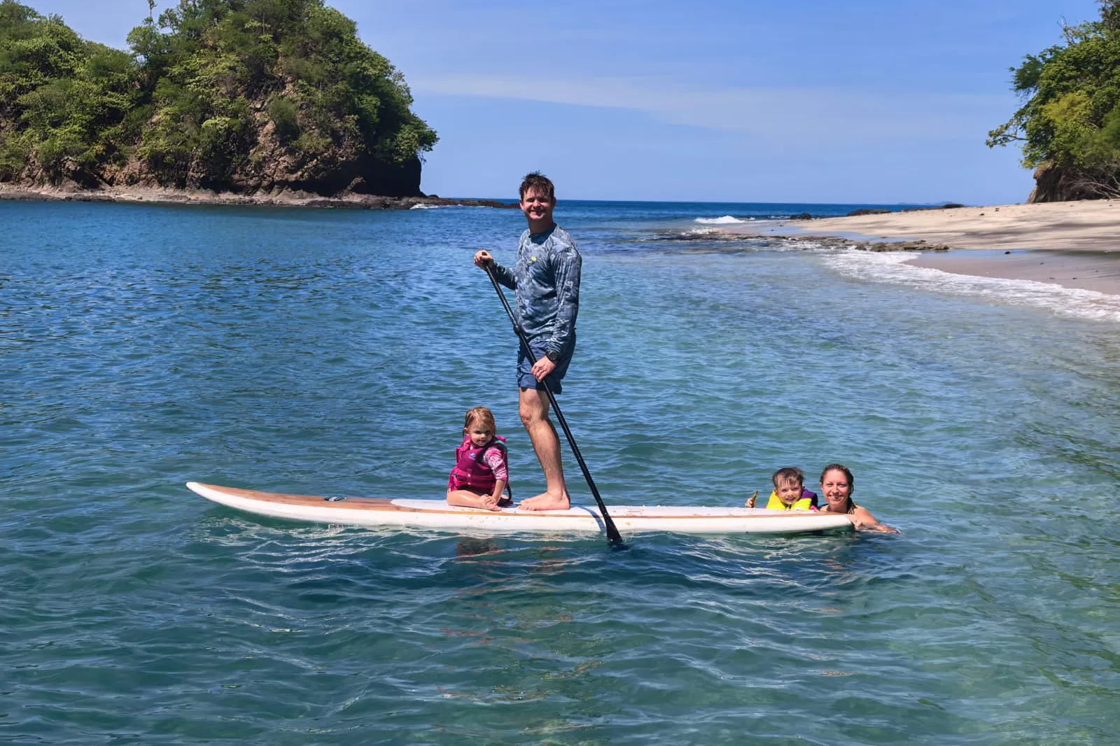 Family paddleboarding beside the boat in Papagayo